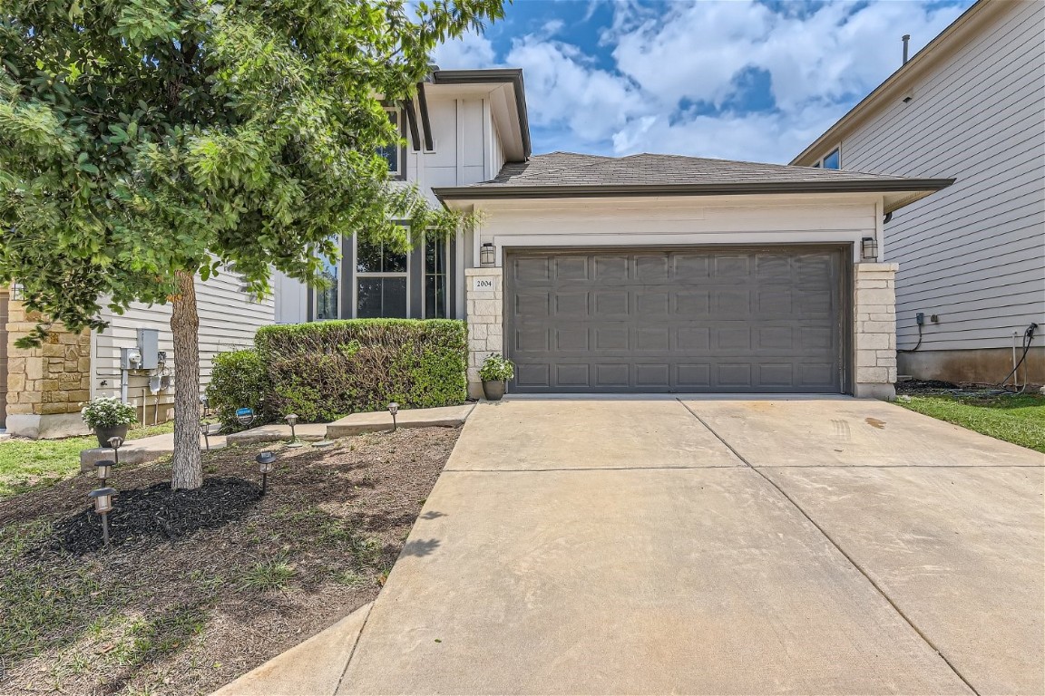 a front view of a house with a yard and garage