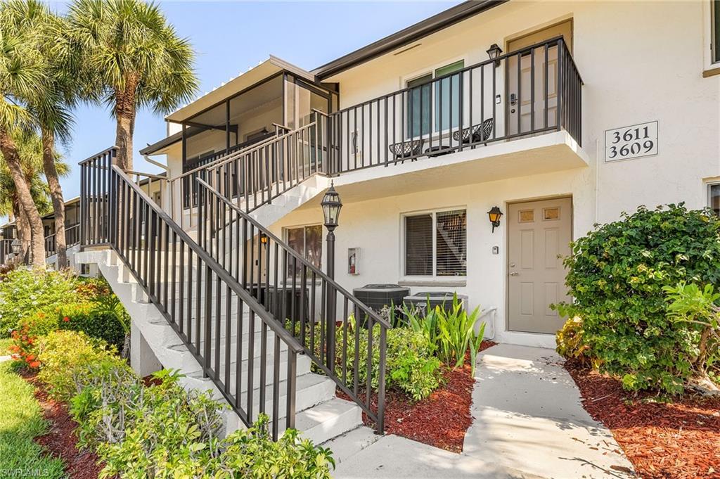 View of front of property featuring a balcony and central AC