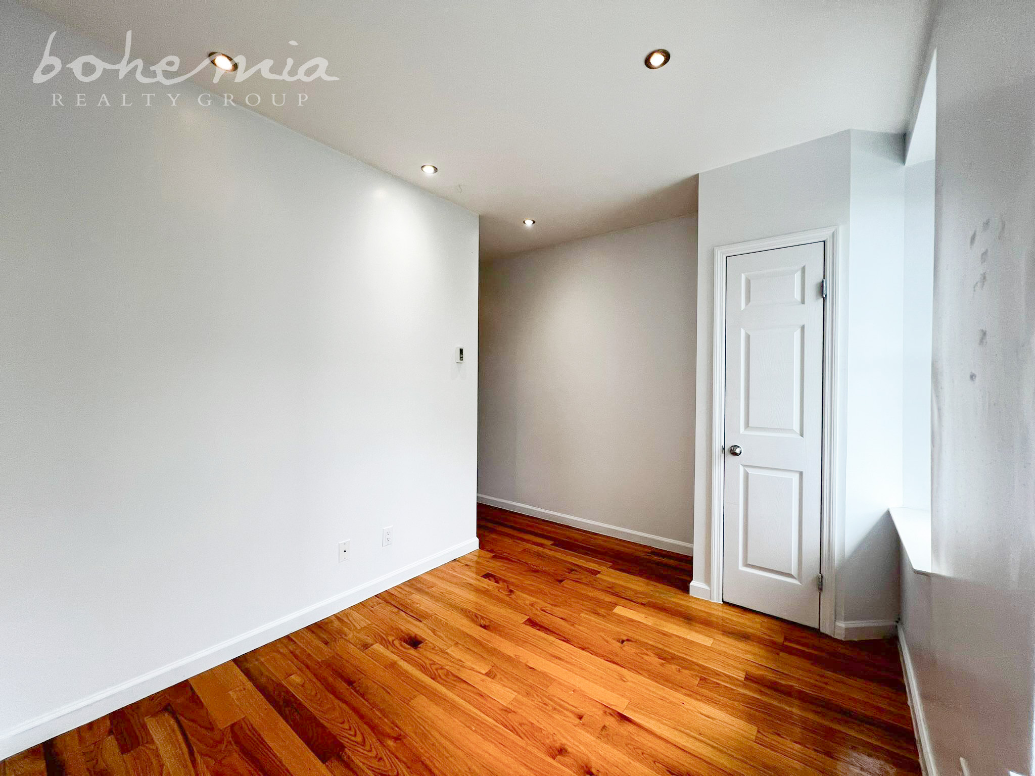 a view of empty room with wooden floor