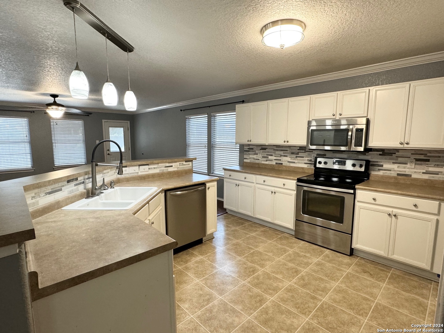 a kitchen with a stove a sink and a microwave