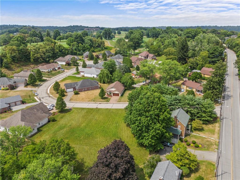 an aerial view of a house with a garden and lake view