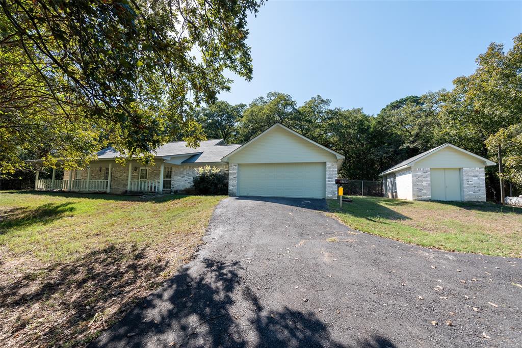 a front view of house with yard and trees in the background