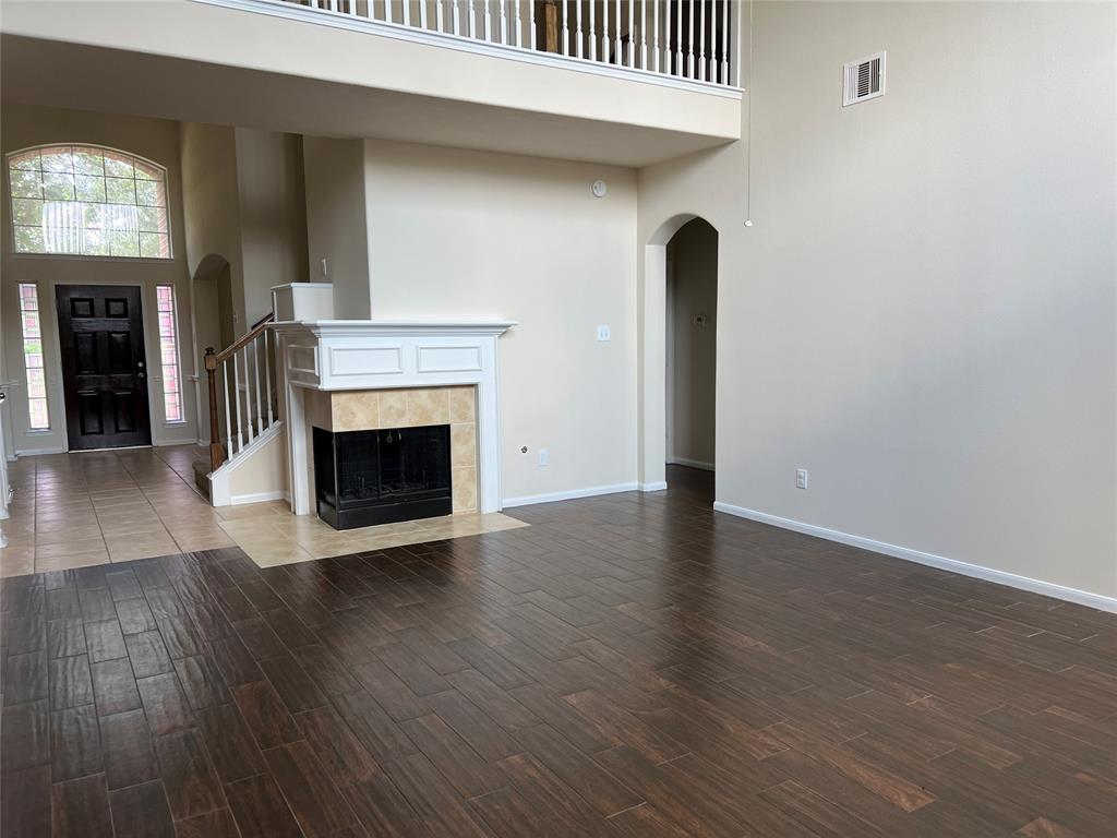 an empty room with wooden floor and a fireplace