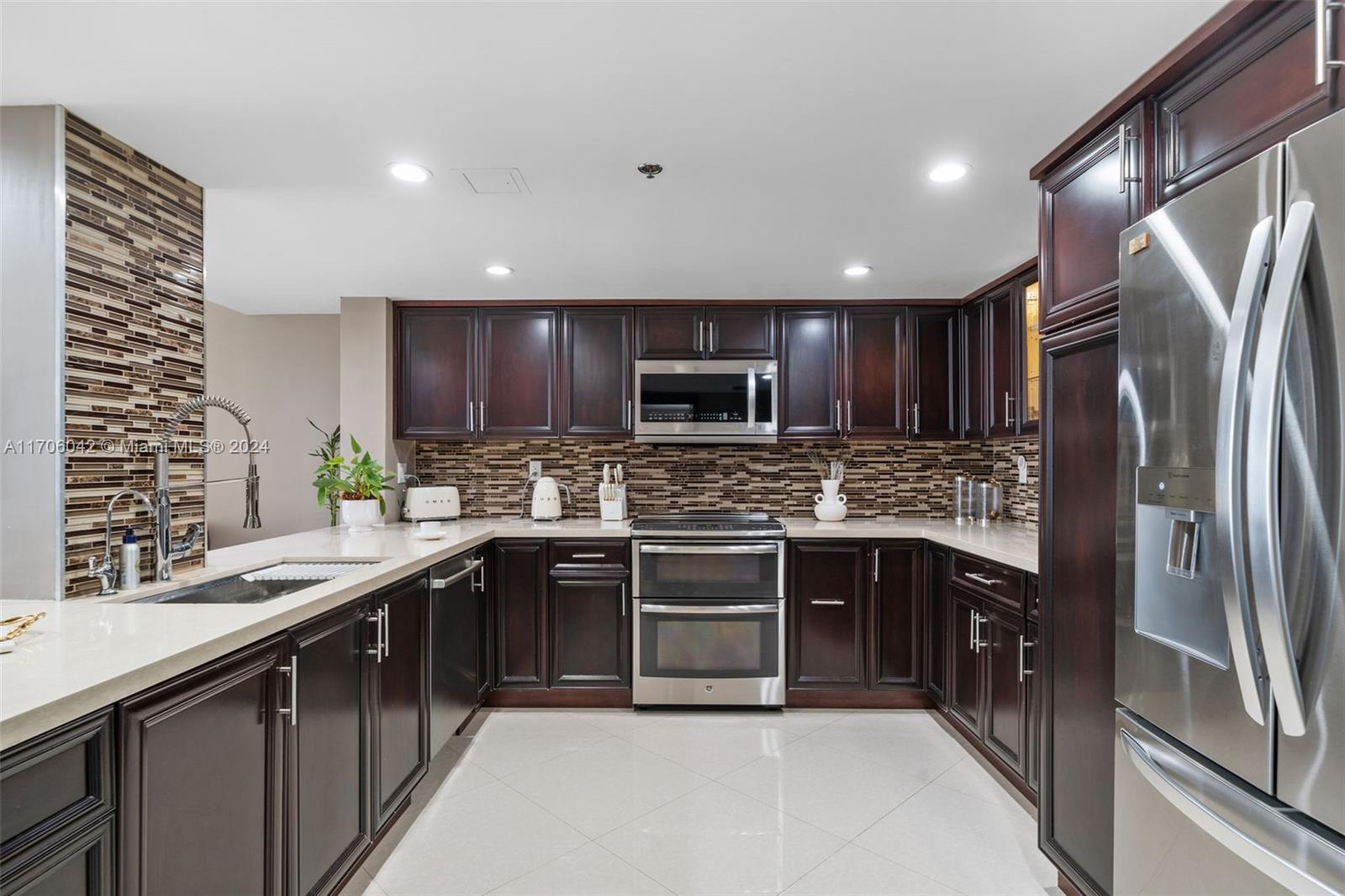 a kitchen with stainless steel appliances granite countertop a sink stove and refrigerator