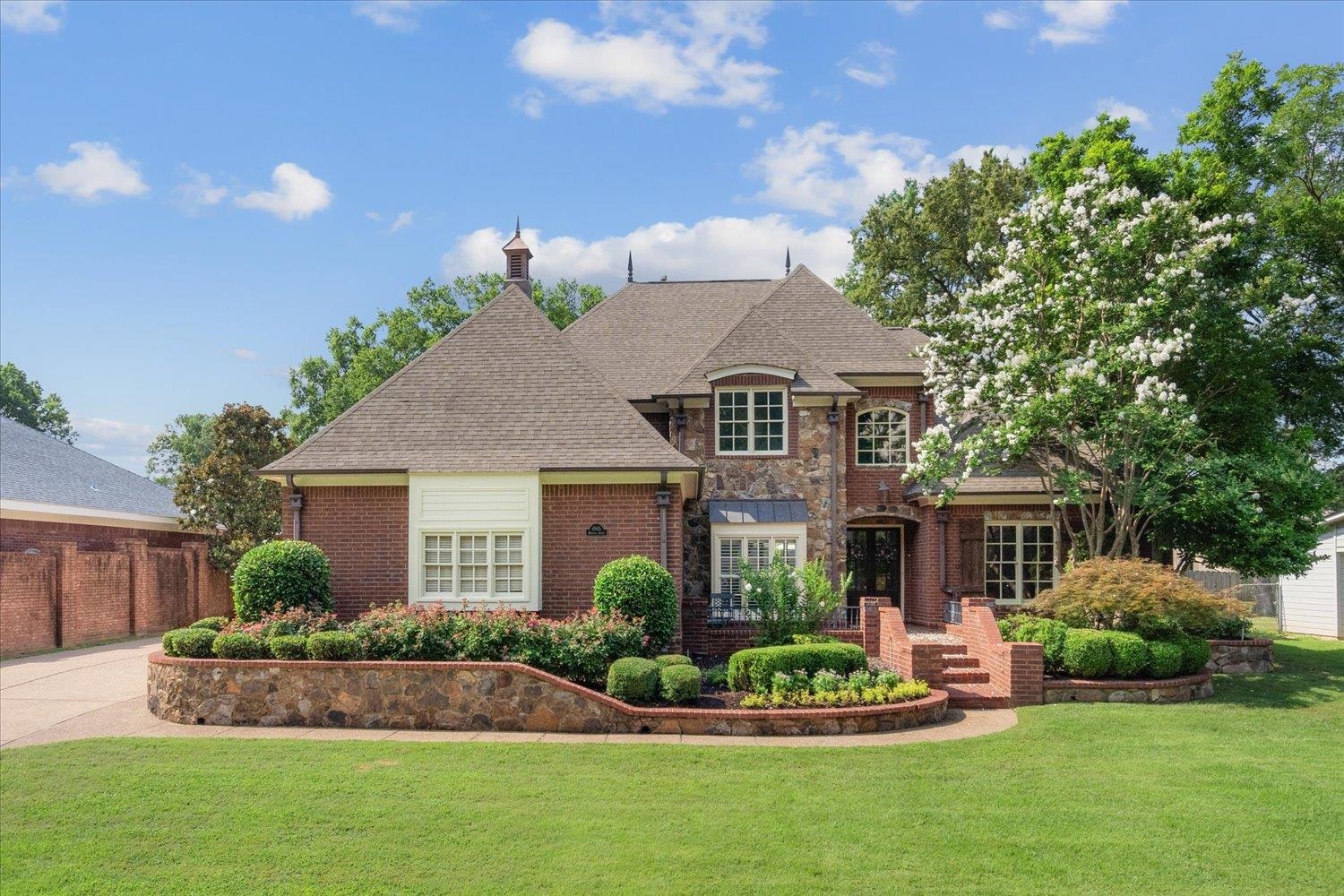 a front view of a house with a yard and potted plants