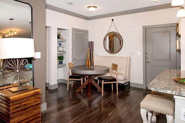 a living room with furniture a table and wooden floor