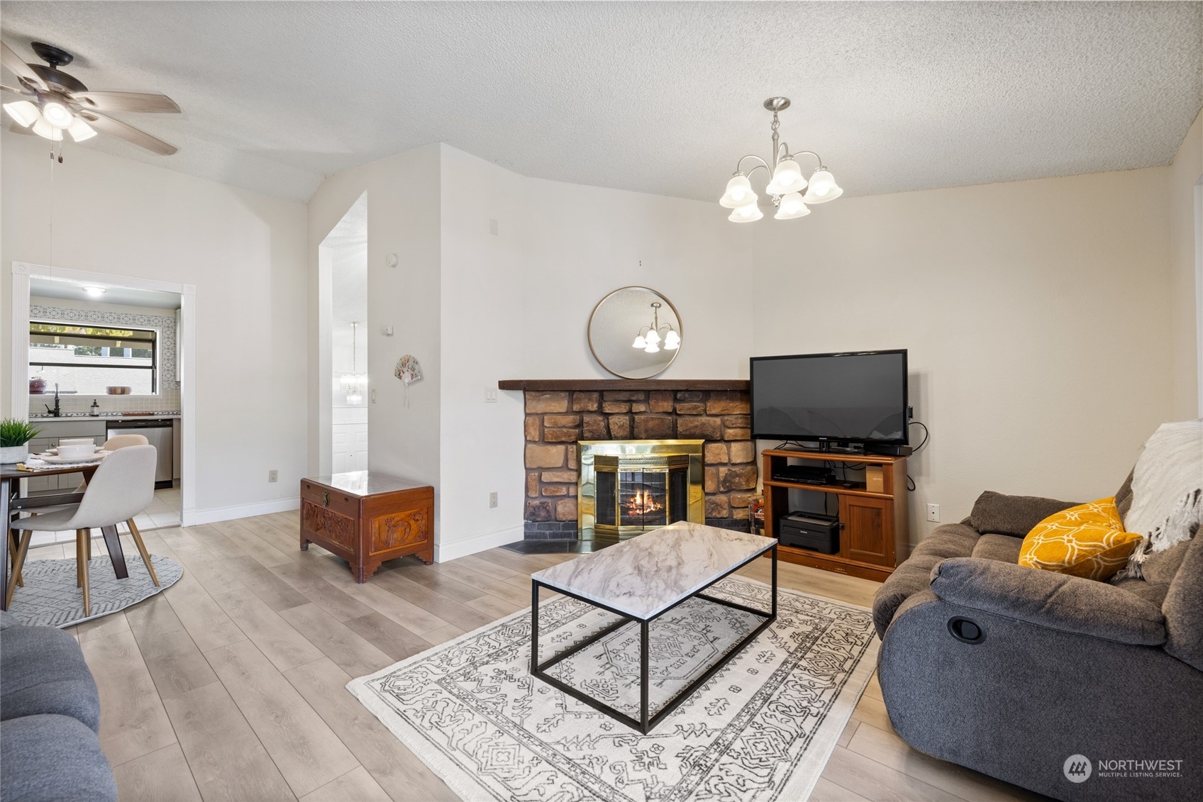 a living room with furniture a flat screen tv and kitchen view