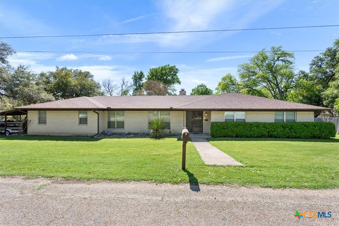 a view of a house with a yard and tree s