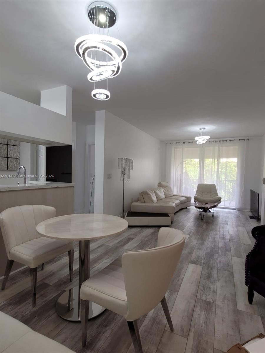 a living room with furniture a flat screen tv and kitchen view