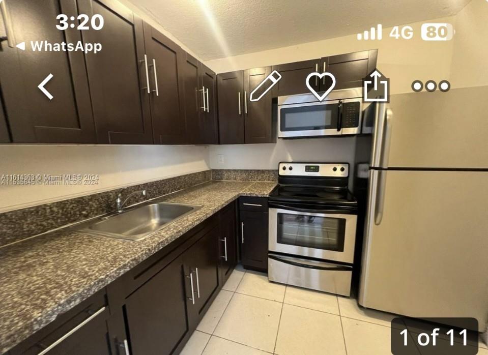 a kitchen with granite countertop a refrigerator and a stove