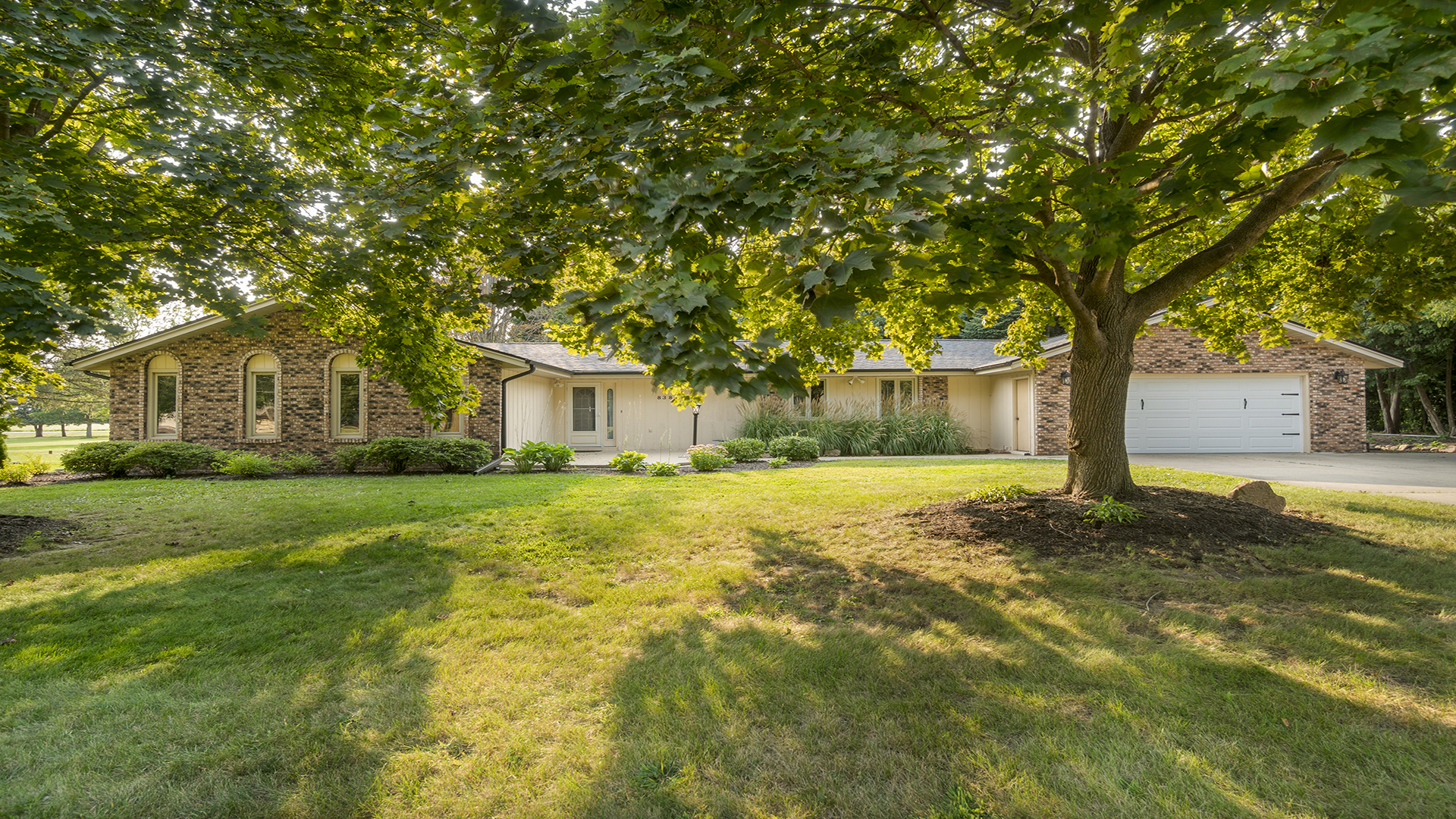 a front view of a house with yard and green space