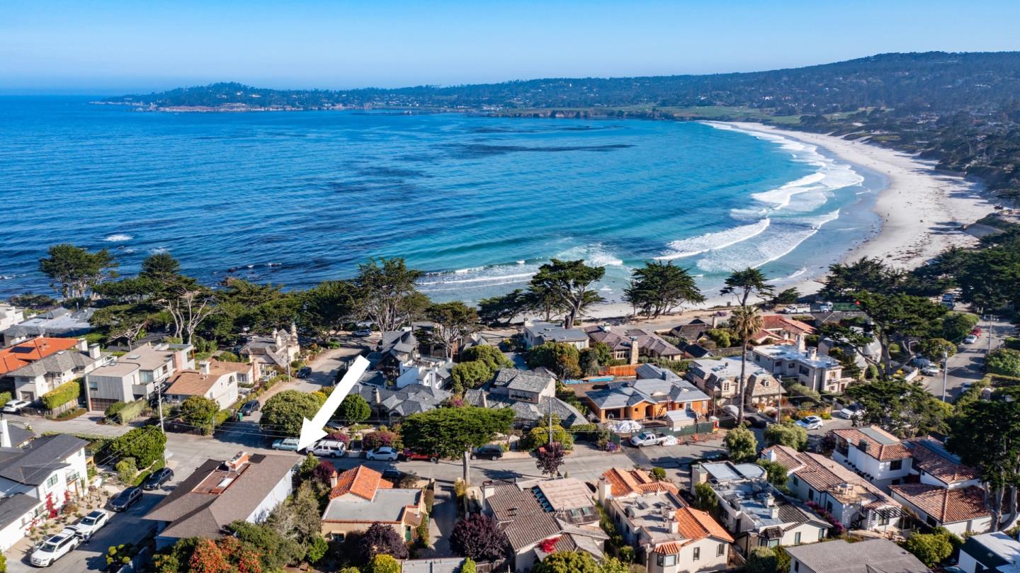 an aerial view of ocean and residential houses with outdoor space