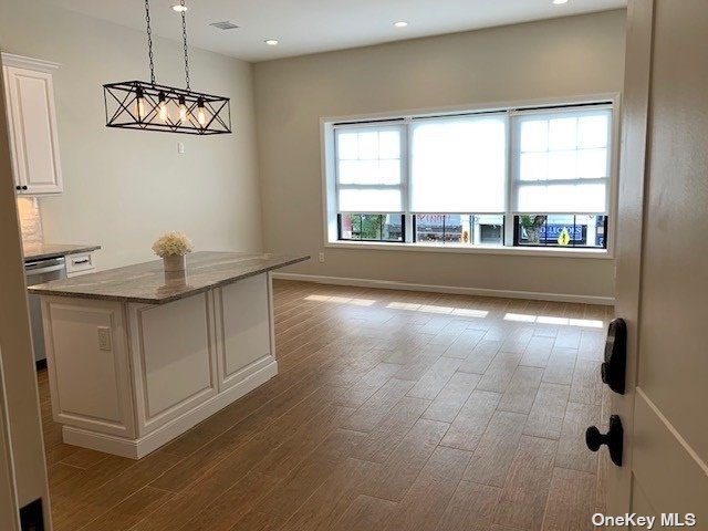 a view of a livingroom with a window and wooden floor