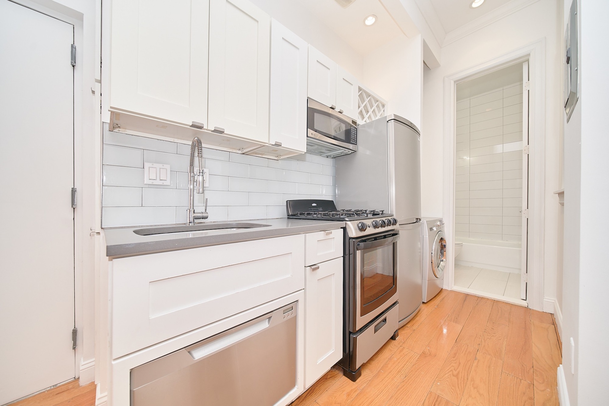 a kitchen with stainless steel appliances white cabinets and a sink