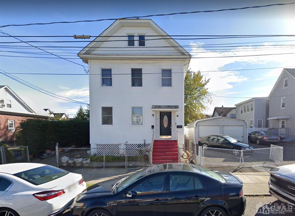 a front view of a house with cars parked