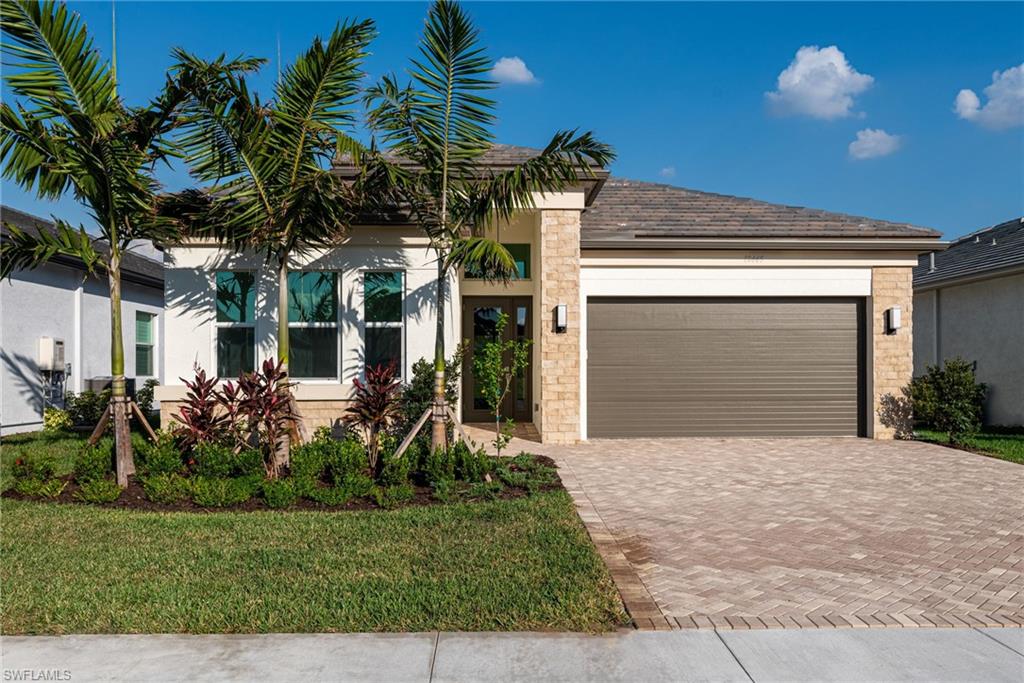 View of front of home with a garage and a front lawn