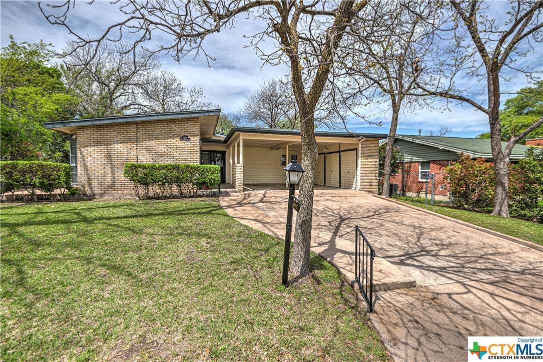 a view of a house with yard and a tree