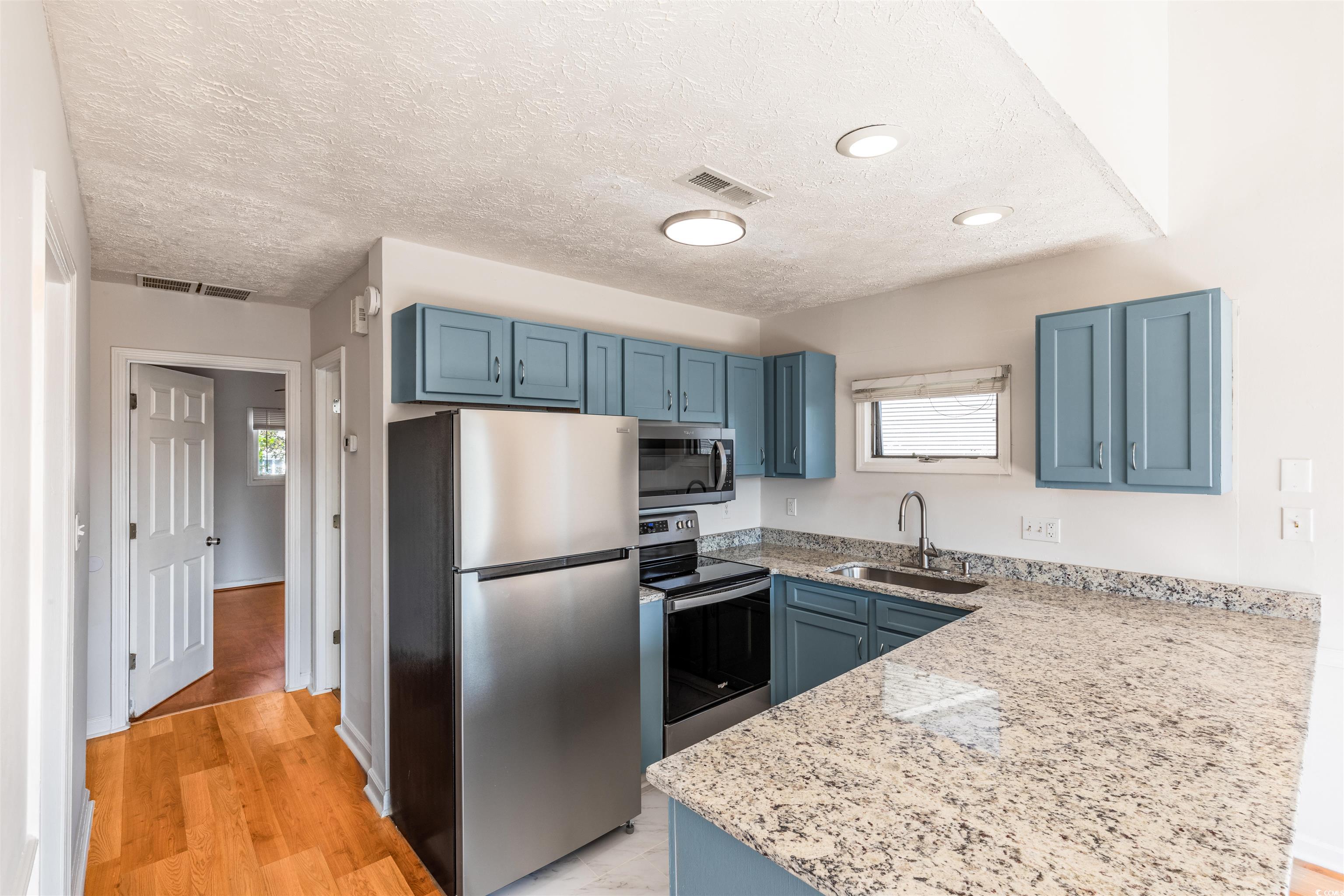 Kitchen featuring light wood-type flooring, stainl