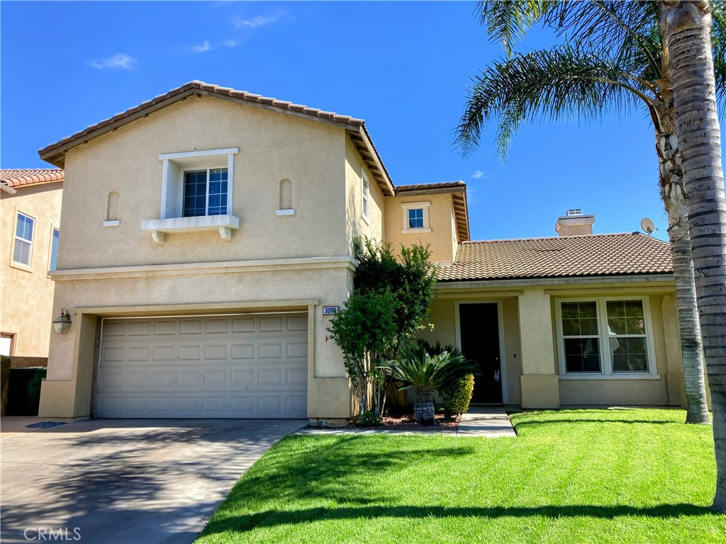 a front view of a house with a yard and garage