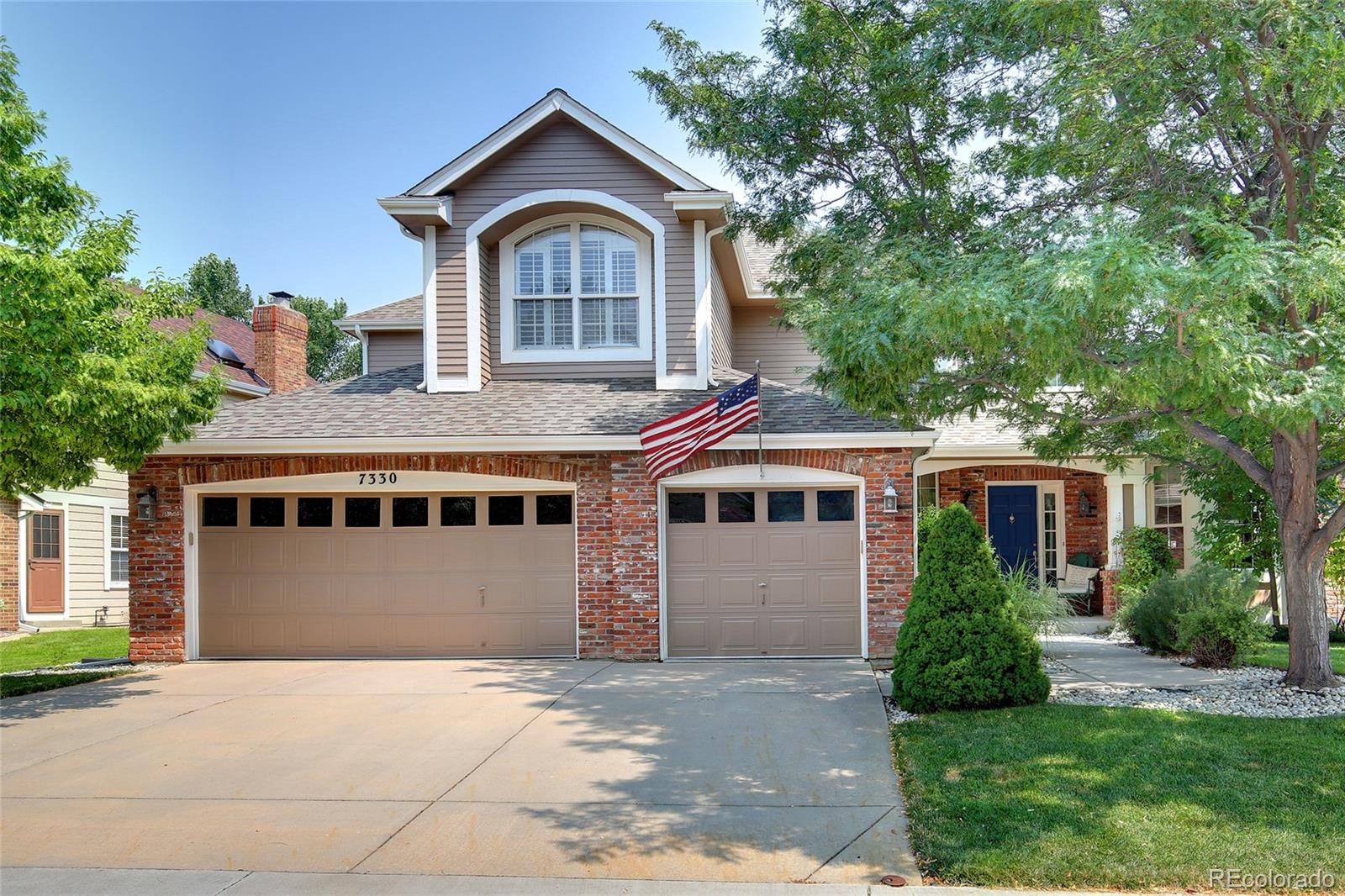 a front view of a house with a yard garage and outdoor seating