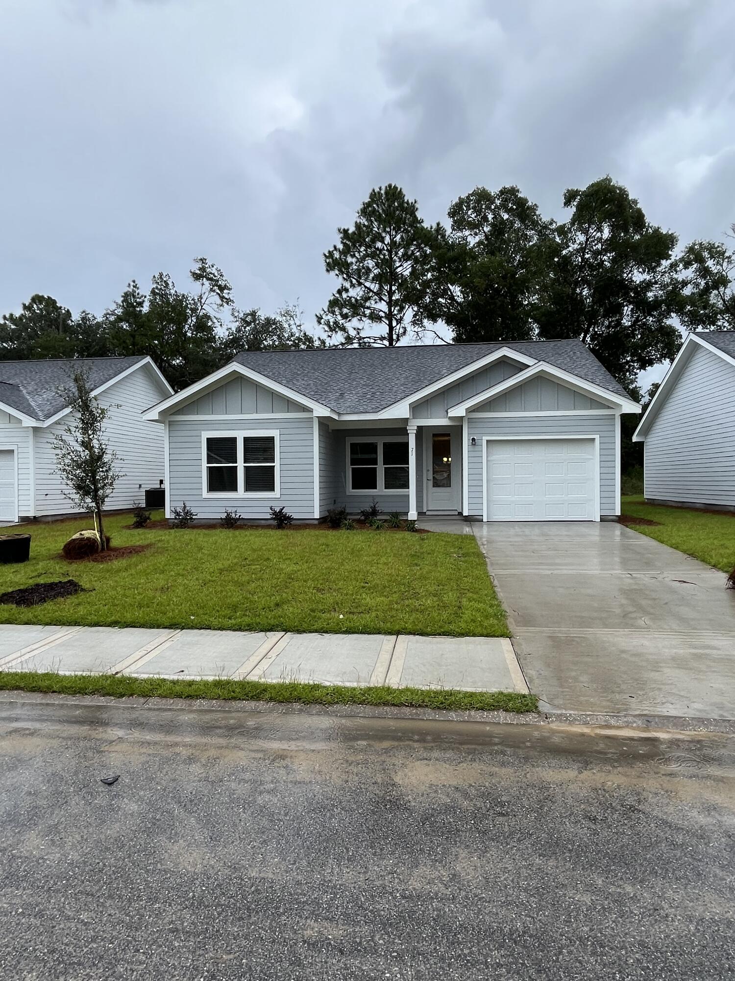 a front view of a house with a garden and trees