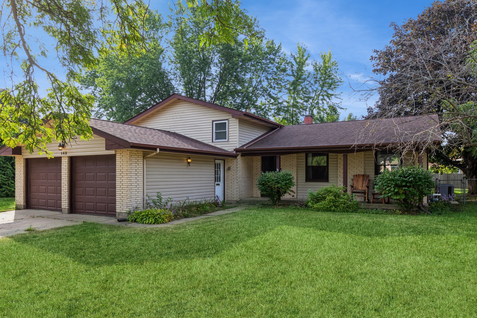 a front view of a house with a yard and trees