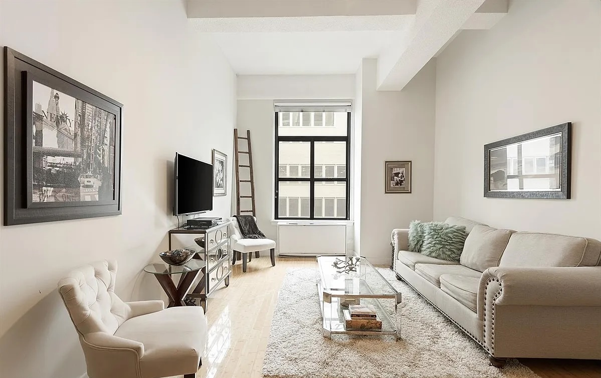 a living room with furniture a large window and a flat screen tv