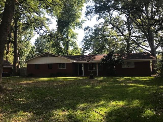 a front view of a house with yard and green space