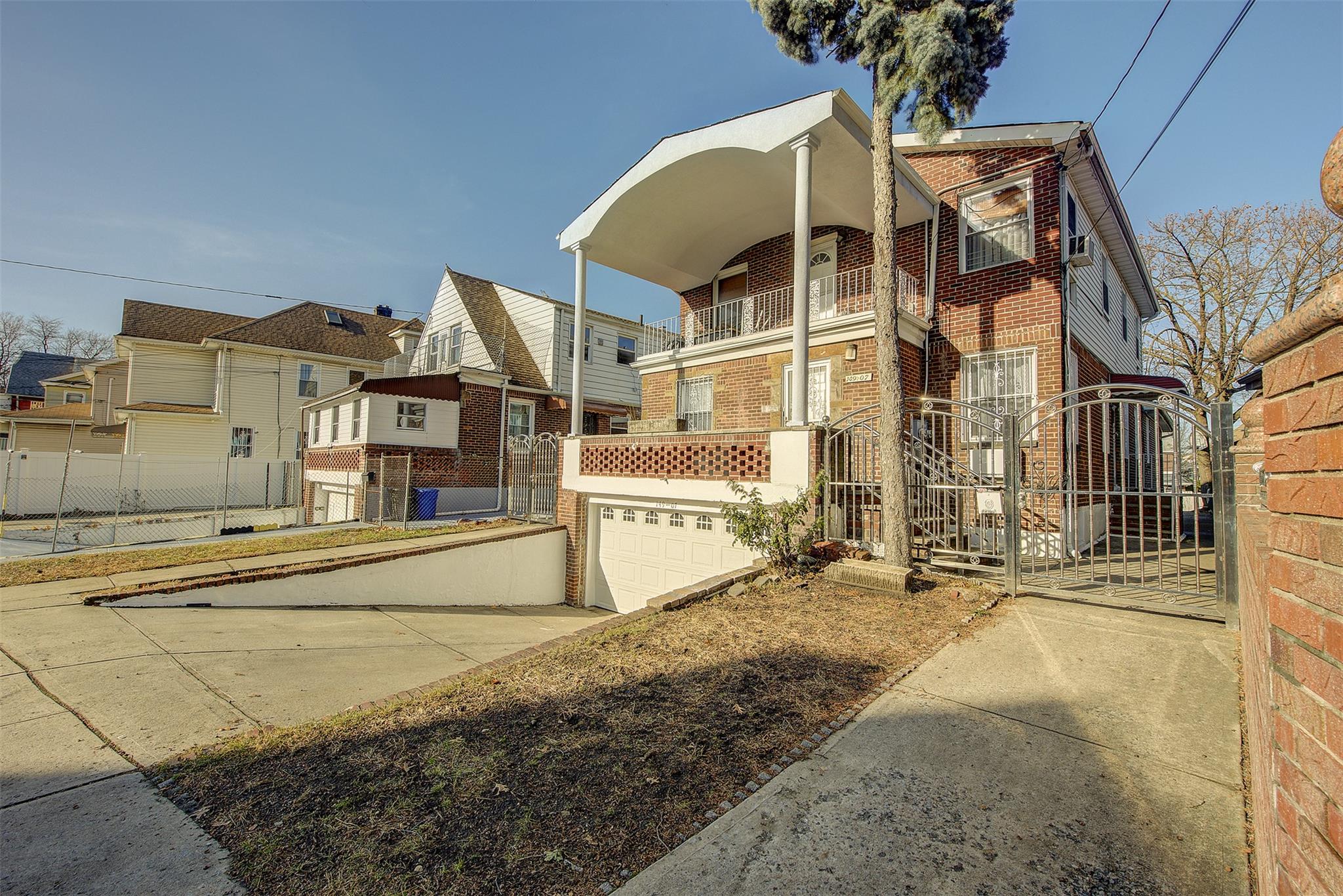 View of front of home featuring a garage and a balcony