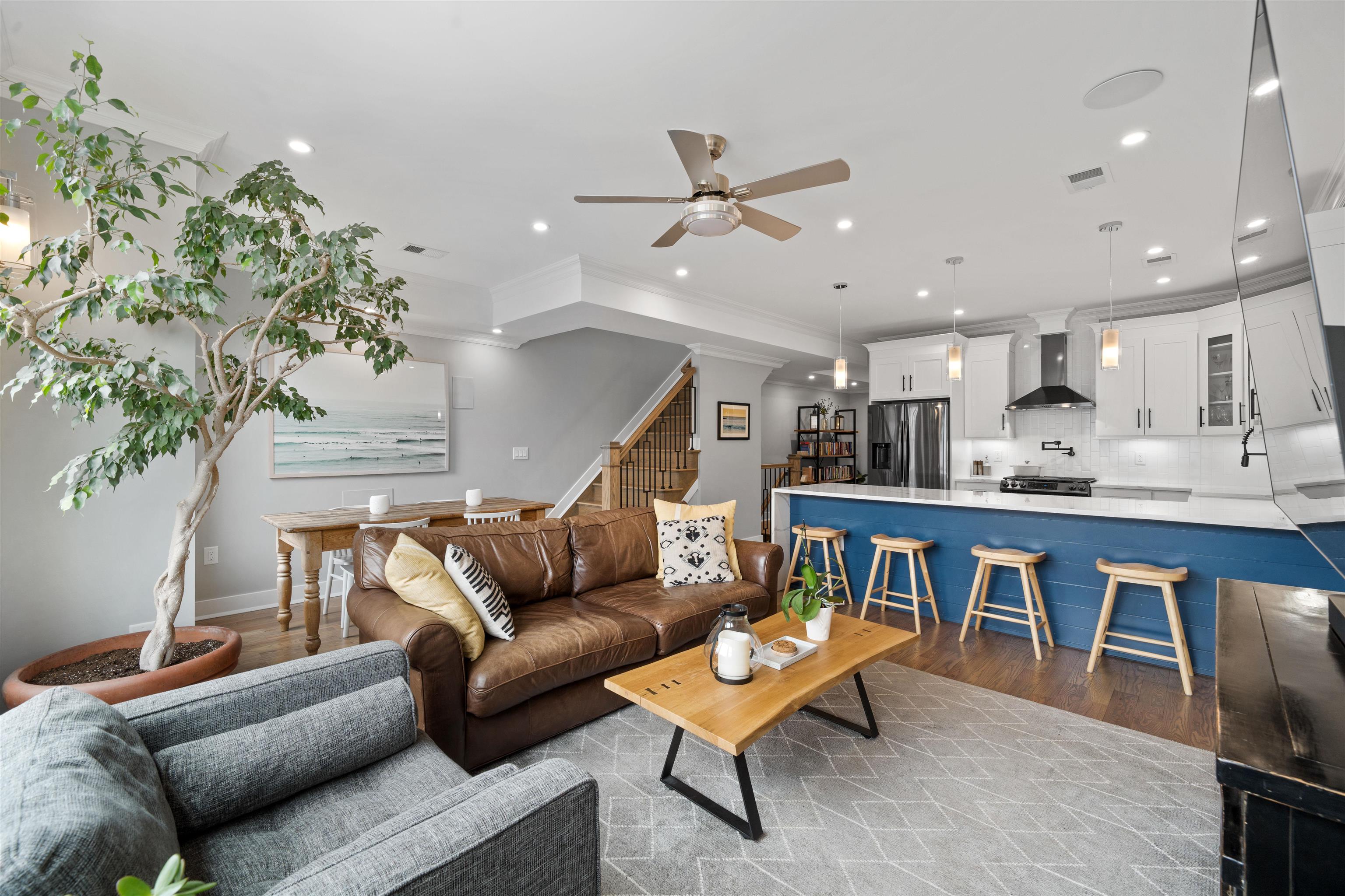 a living room with furniture kitchen view and a potted plant