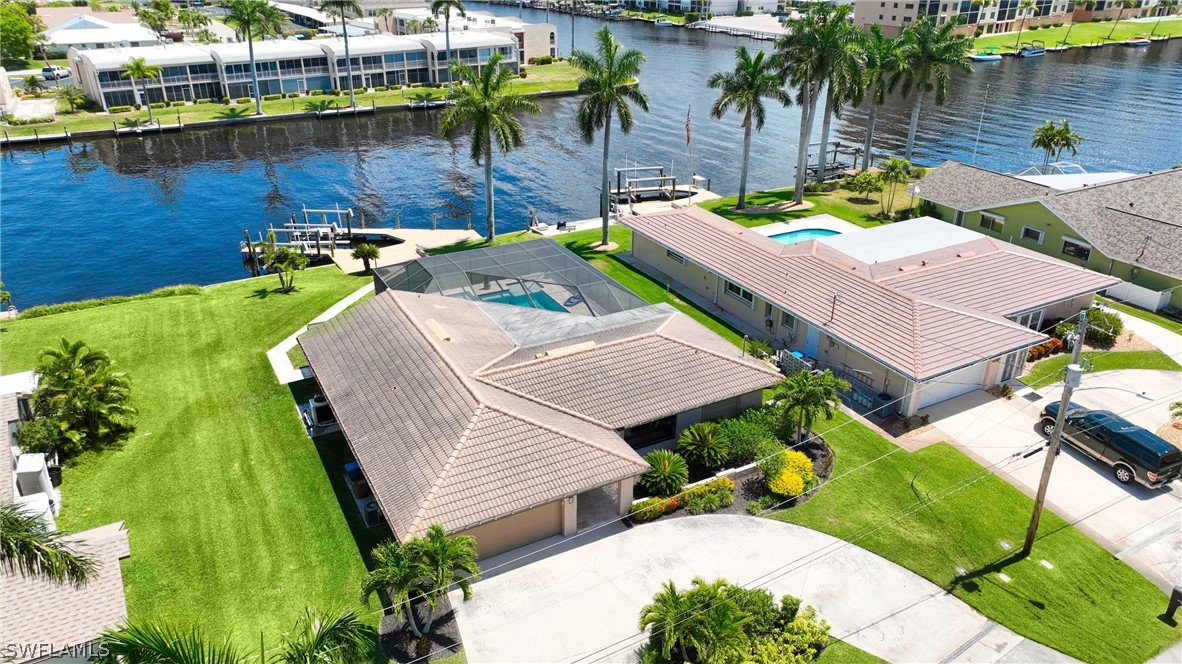 an aerial view of a house with swimming pool and outdoor seating