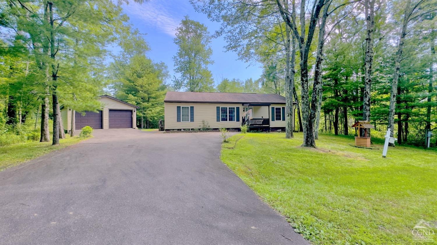 a view of a house with a patio and a yard