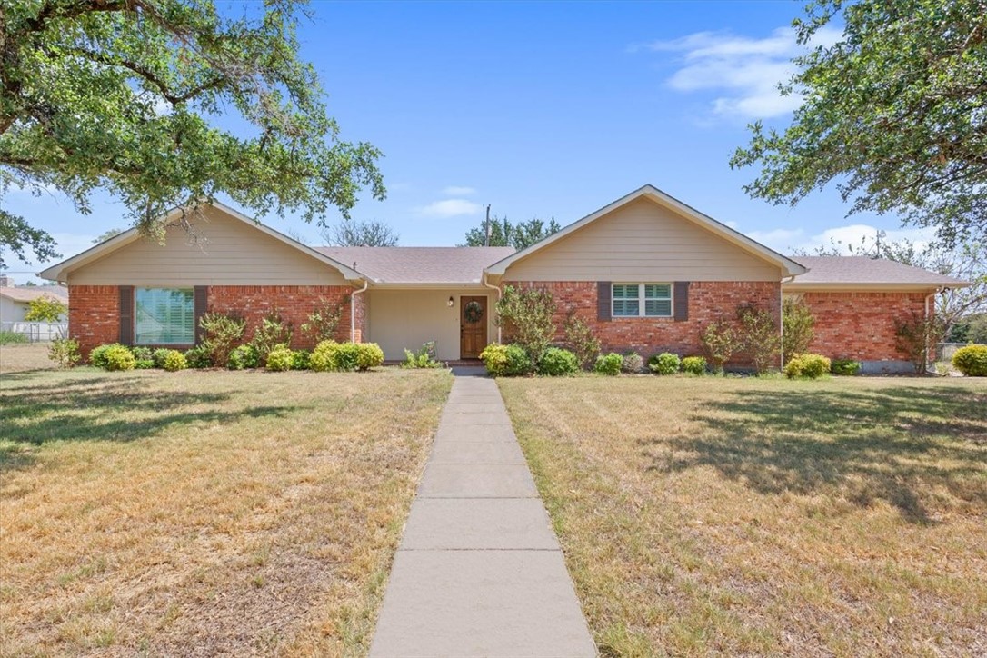 a front view of a house with a yard and potted plants