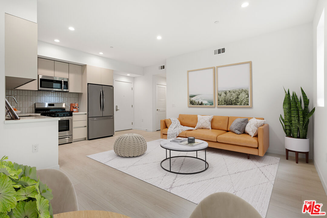 a living room with furniture kitchen and a potted plant