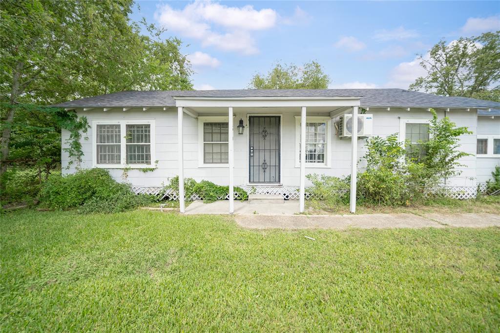 front view of a house with a yard and potted plants