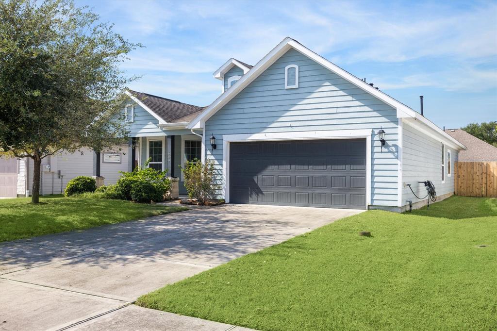 Charming ranch-style home with a stylish baby blue exterior, an oversized covered front porch, and lush landscaping.