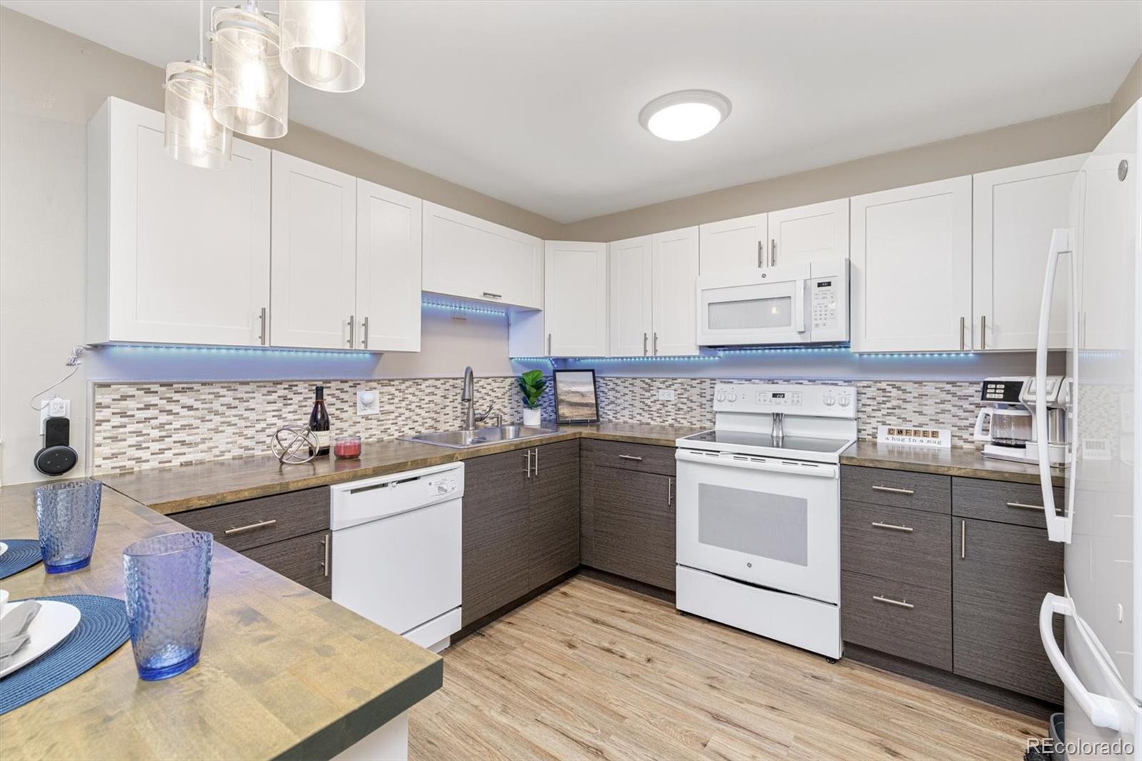 a kitchen with stainless steel appliances kitchen island granite countertop a sink cabinets and wooden floor