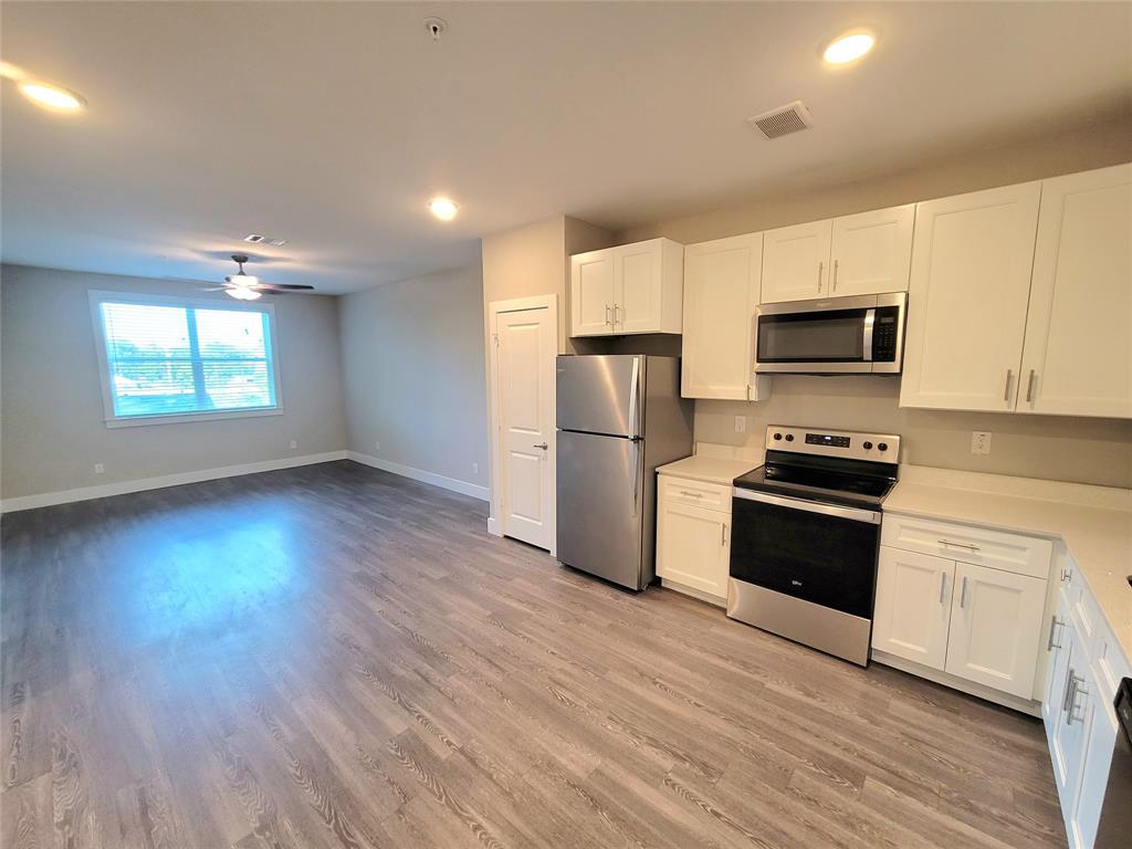 a kitchen with granite countertop a refrigerator and a stove top oven