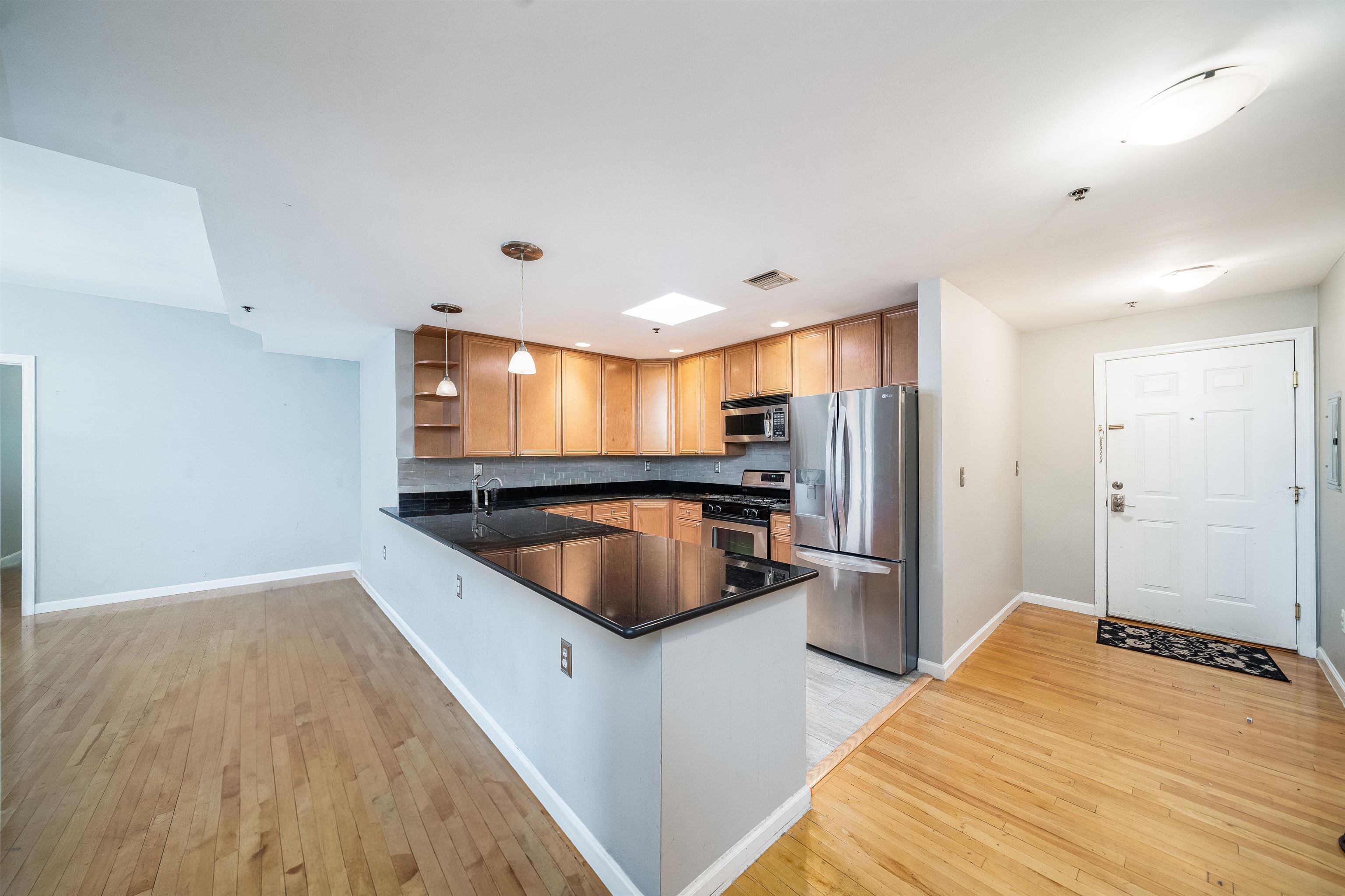 a kitchen with stainless steel appliances granite countertop a sink and a refrigerator