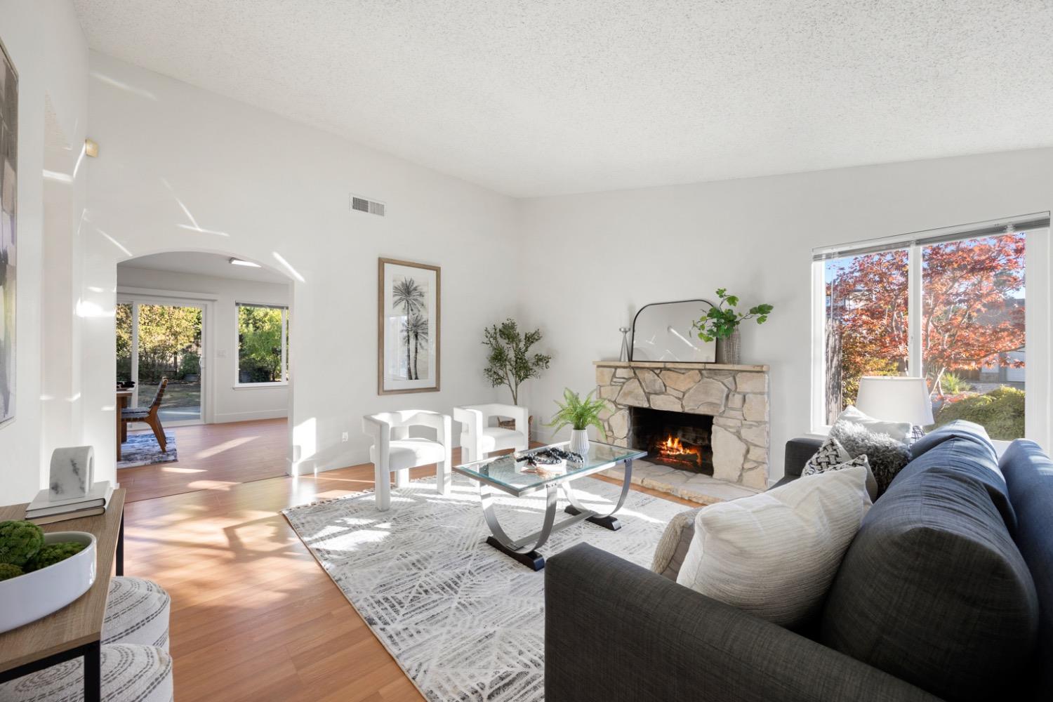 a living room with furniture a fireplace and a large window