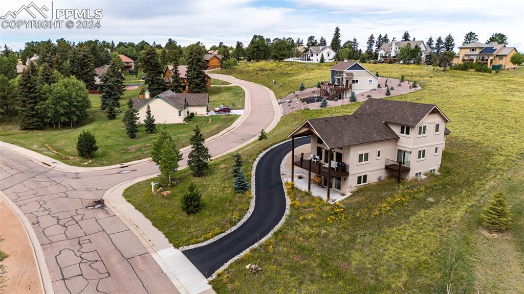 an aerial view of a house with outdoor space lake view and trees all around