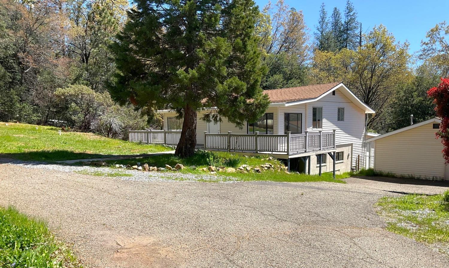 a front view of a house with a garden and trees