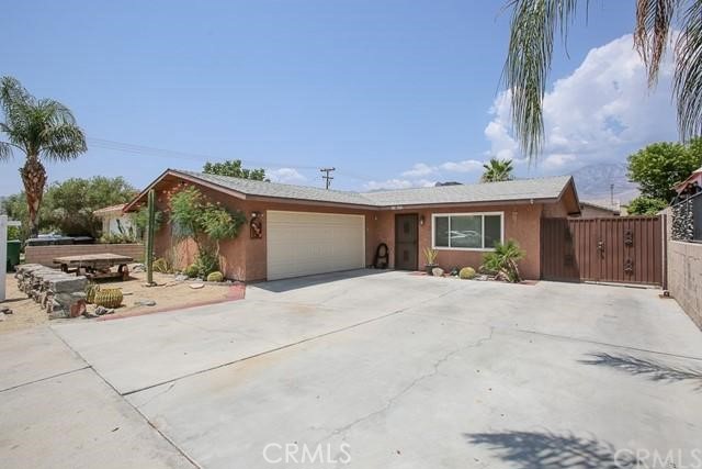 a view of a house with a patio and a yard