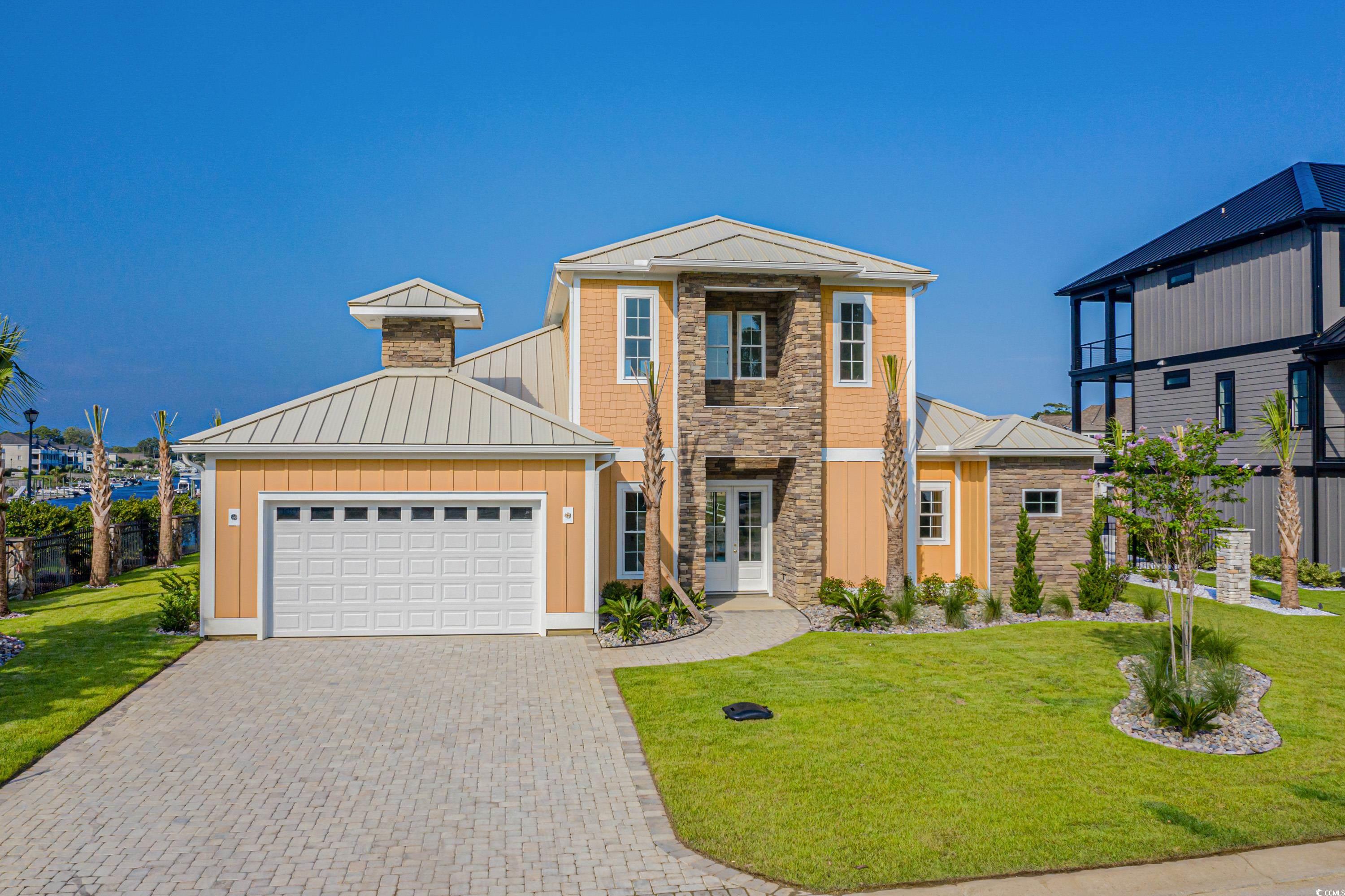 View of front of house with a garage and a front y