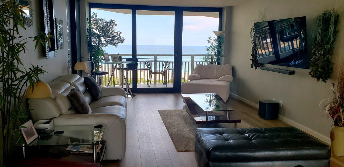 a living room with furniture and a floor to ceiling window