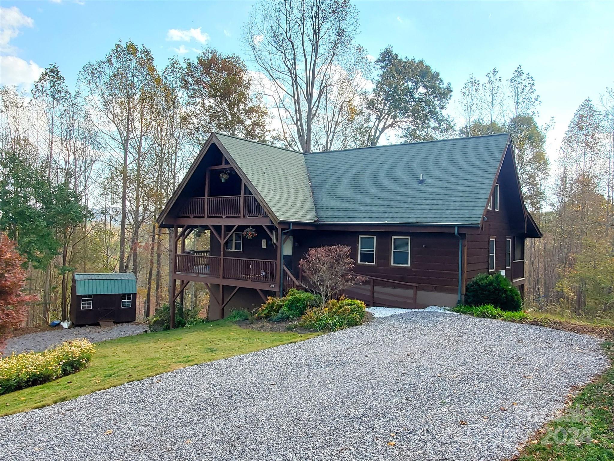 a front view of a house with a garden and trees