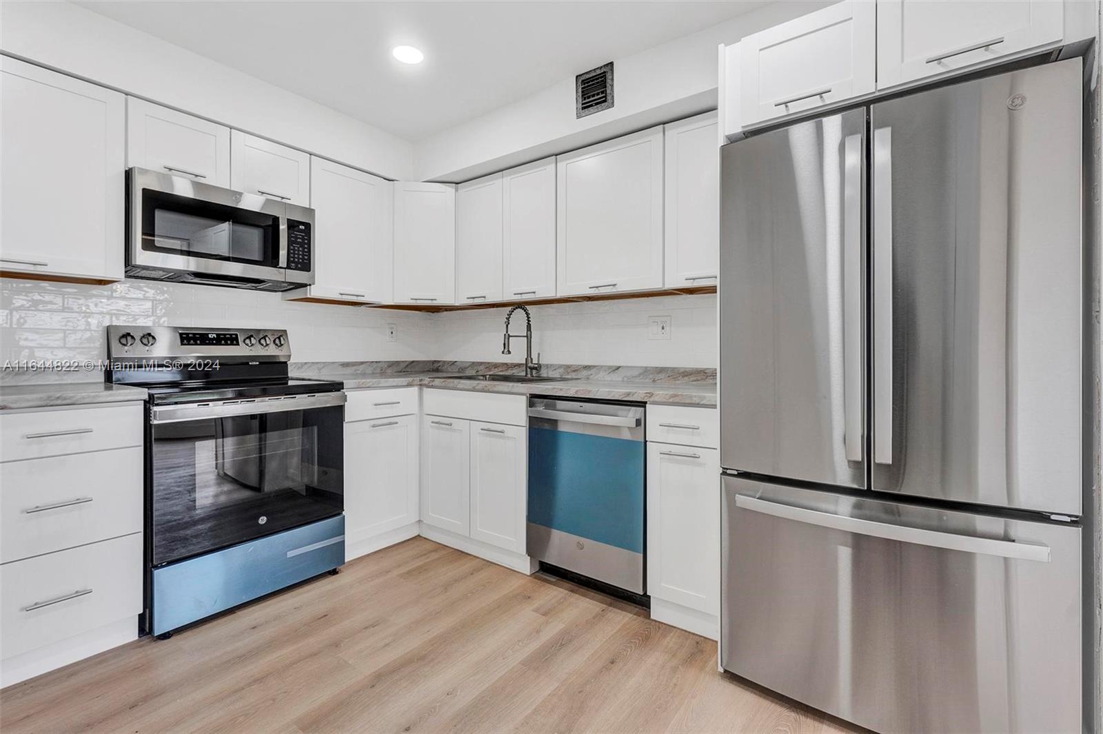 a kitchen with stainless steel appliances a refrigerator sink and microwave