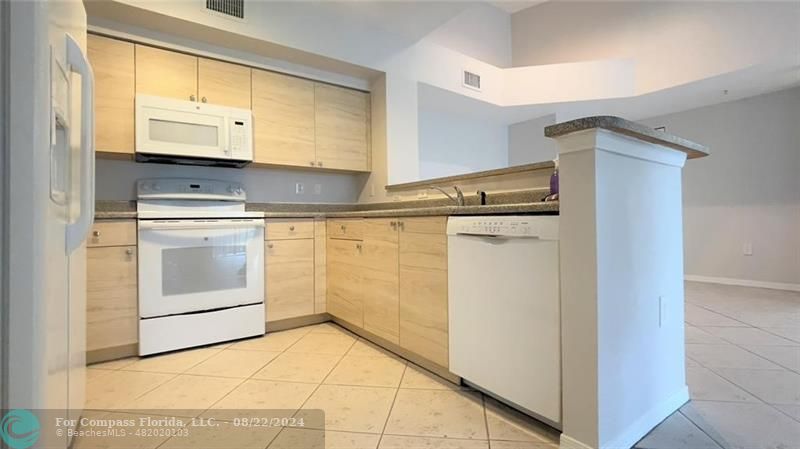 a kitchen with stainless steel appliances granite countertop a stove and a refrigerator