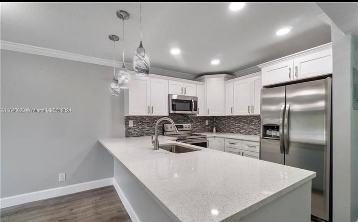 a kitchen with microwave a refrigerator and a sink