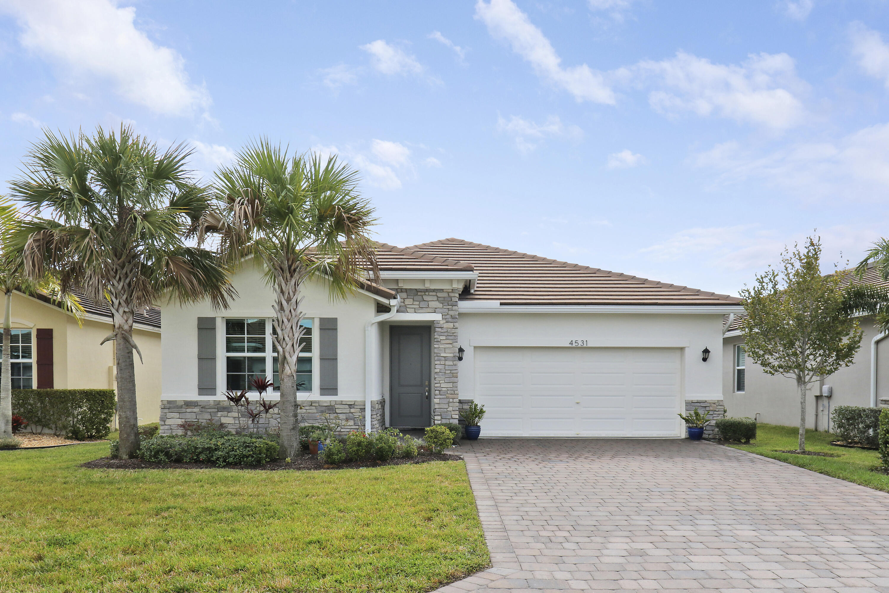 a front view of a house with a garden and yard